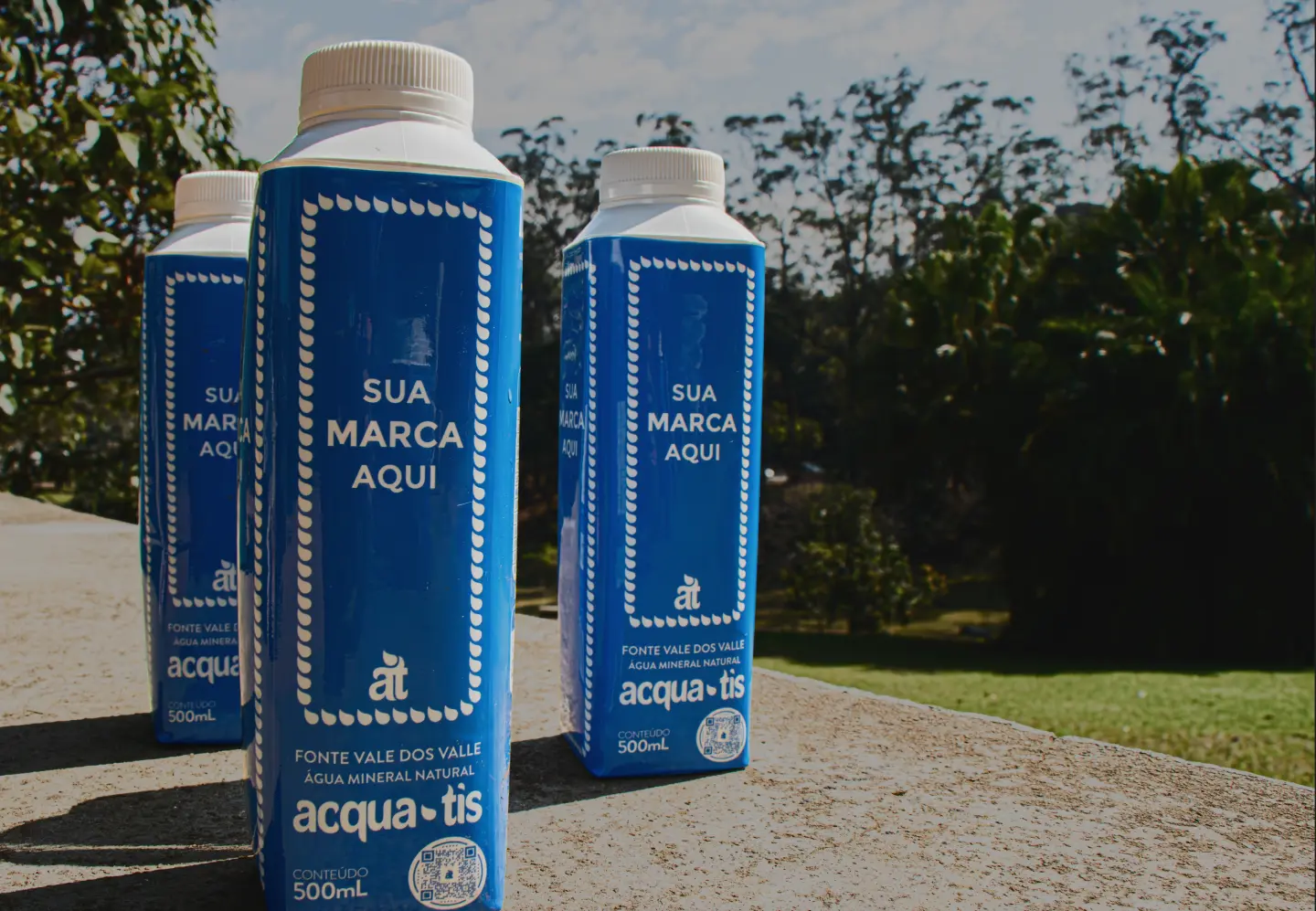 três garrafas de Acqua.Tís em um fundo de natureza